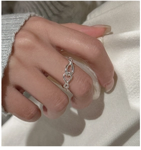 Detailed close-up of a silver S925 sterling silver knotted soft chain ring on a hand