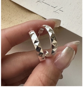 Gros plan de créoles en argent sterling S925 avec texture géométrique gravée CNC