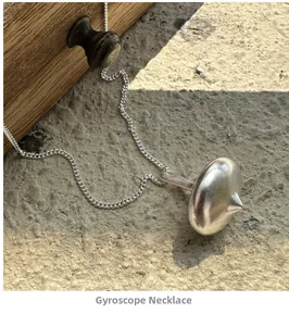 Detailed view of S925 sterling silver spinning top pendant with a brushed metal texture
