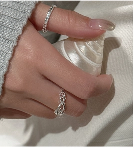 Detailed view of S925 sterling silver knotted ring and flower band on model hand