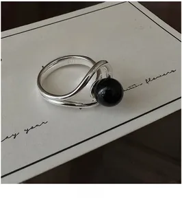 Detailed close-up of S925 sterling silver crisscross ring with black onyx bead