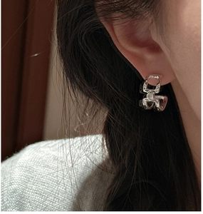 Close-up of S925 sterling silver layered earrings featuring a small zircon stone