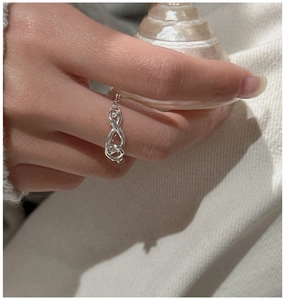 Detail view of S925 sterling silver knotted soft chain ring on a model hand with warm tones