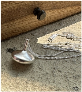 Macro shot of S925 sterling silver hallmark on spinning top pendant necklace band