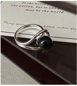 Detail of S925 sterling silver ring featuring a black agate bead on a sleek curved band