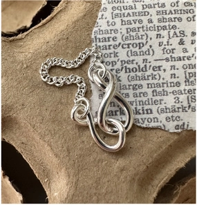 Macro shot of S925 sterling silver infinity knot chain ring on vintage paper