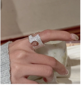 Macro shot of silver ring featuring vertical handcrafted textures and hollow structures