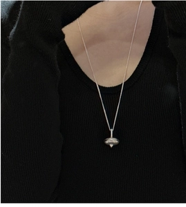 Detailed close-up of a S925 sterling silver spinning top pendant on long chain necklace