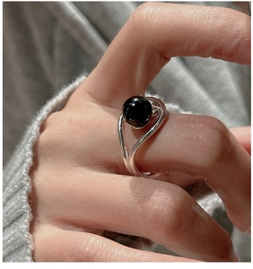 Detailed view of S925 silver wavy ring with a black agate bead on a hand model