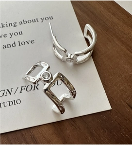 Macro detail of S925 sterling silver geometric earrings with sparkling zircon stones
