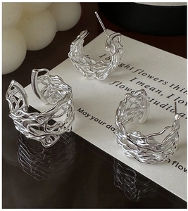 Macro shot of silver S925 sterling silver hollow C-shape earrings with liquid metal texture
