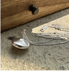 Macro detail of S925 sterling silver gyroscope pendant with matte finish on stone