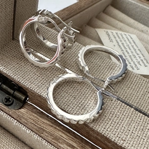 Minimalist S925 sterling silver gear-shaped hoop earrings with wavy design on gray texture