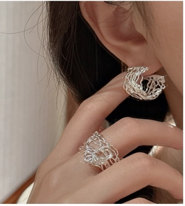 Detail of S925 sterling silver open ring and C-shaped earrings with lava texture