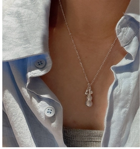 Detail of 925 sterling silver gourd pendant necklace on a model wearing a blue shirt