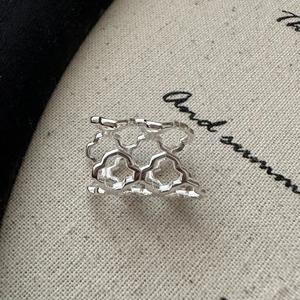 Vintage geometric hollow silver ring with artistic floral patterns on linen fabric