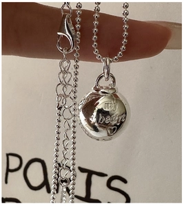 Macro detail of S925 sterling silver ball pendant necklace with my heart engraving