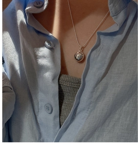 Macro detail of polished S925 sterling silver ball pendant necklace with fine engravings