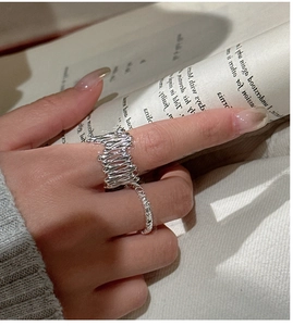Détail d'une bague en métal liquide argenté et d'un anneau en zircon sur un livre