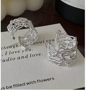 Close-up of S925 sterling silver hollow woven C-shaped earrings on artistic card