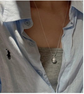 Close-up of minimalist S925 sterling silver beaded necklace with round engraved pendant
