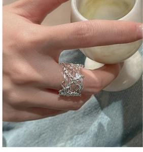 Detailed view of an S925 silver hollow woven ring with liquid metal organic texture