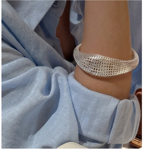 Detailed view of silver hollow mesh cuff bracelet in a minimalist open design