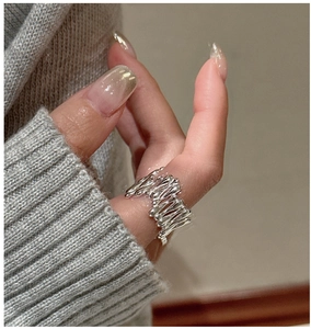 Vue détaillée d'une bague en argent S925 style métal liquide avec texture fondue sur le doigt