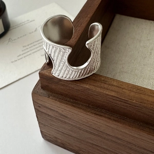 Minimalist S925 sterling silver open ring with vintage wavy texture on a wooden box