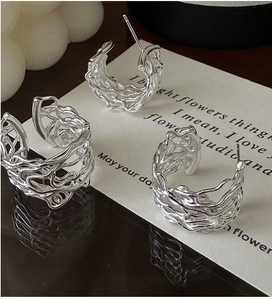 Macro detail of S925 sterling silver hollow earrings with modern liquid metal texture