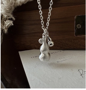 Macro shot of brushed S925 silver gourd pendant necklace with white zircon stone inlay