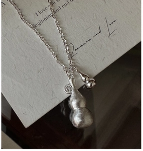Macro detail of silver double gourd necklace with brushed texture and tiny zircon inlay