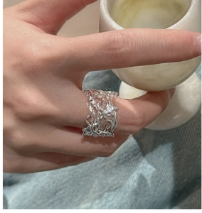 Close-up of S925 silver woven hollow ring with an irregular melted texture design