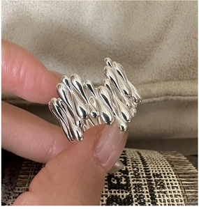 Vue macro de la bague en argent S925 avec textures organiques de métal fondu et gouttes