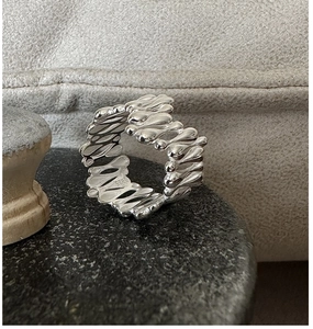 Détail macro d'une bague en argent S925 montrant le poinçon et le design fluide minimaliste