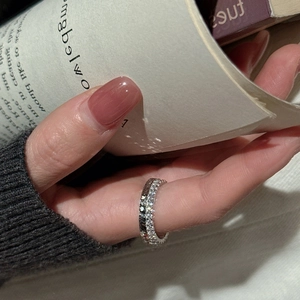 Elegante anello eternity in argento sterling S925 con zirconi indossato sulla mano su un libro