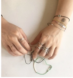 Close-up of retro S925 sterling silver twisted rings and woven bracelets on hand