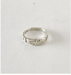 Gros plan d'une bague en argent S925 montrant le motif soleil et le poinçon S925