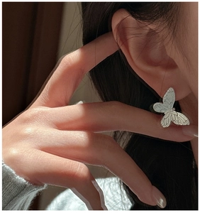 Detail of S925 sterling silver butterfly earrings featuring delicate bionic wing textures