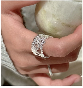 Close-up of a wide S925 silver ring featuring organic lava texture on a natural stone