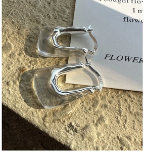 Gros plan de boucles d'oreilles U en argent 925 avec résine sur surface en pierre