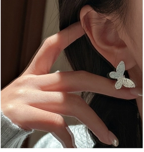 Close-up of S925 sterling silver butterfly stud earring with textured wing details