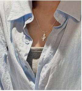 Detail of S925 sterling silver snake chain necklace with three vertical stones on a model