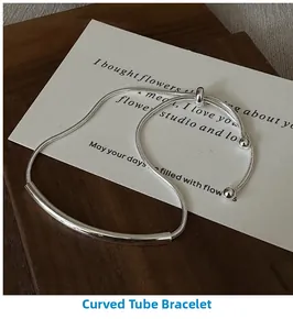 Detail of S925 sterling silver slider bracelet featuring smooth curved tubes on wood