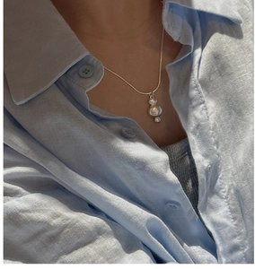 Detail of a S925 silver necklace with three spherical pendants on a snake bone chain