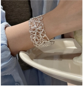 Detailed view of wide 925 sterling silver open bangle with woven hollow wire texture