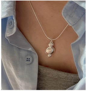 Detail of S925 silver necklace featuring three organic matte pendants on a slim chain