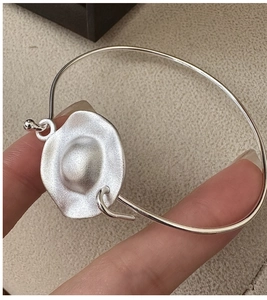 Detailed view of matte S925 sterling silver bangle featuring a hammered textured disk