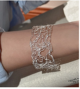 Detail of 925 sterling silver open bangle with modern hollow irregular wavy lines