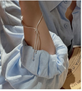 Detail view of S925 silver knot bracelet with snake chain and beads on a model wrist